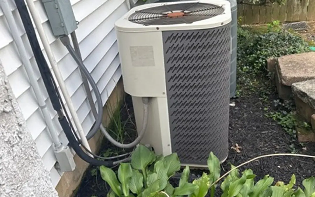 Exterior air-conditioning condenser beside a home.