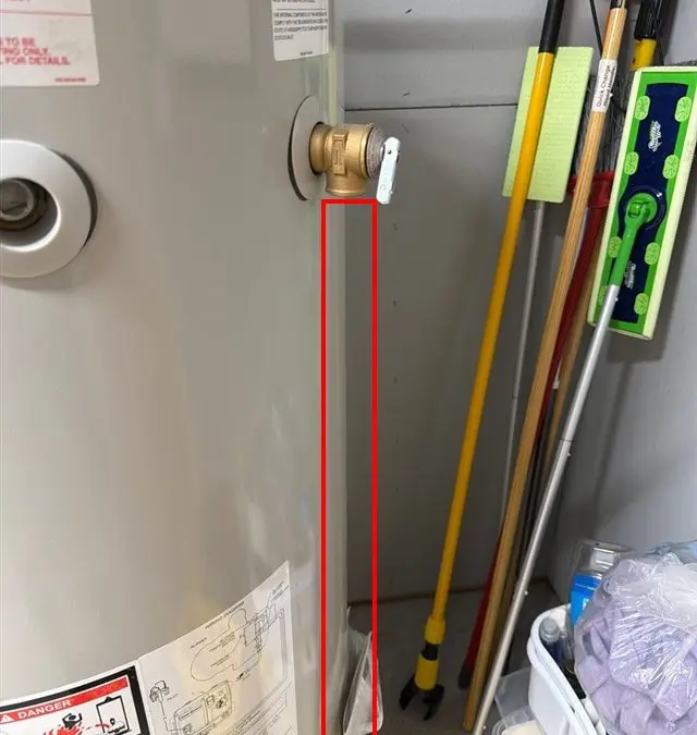 Original inspection photo of a water heater’s temperature-and-pressure relief valve without an attached discharge pipe. An existing red report annotation outlines the area below the valve.