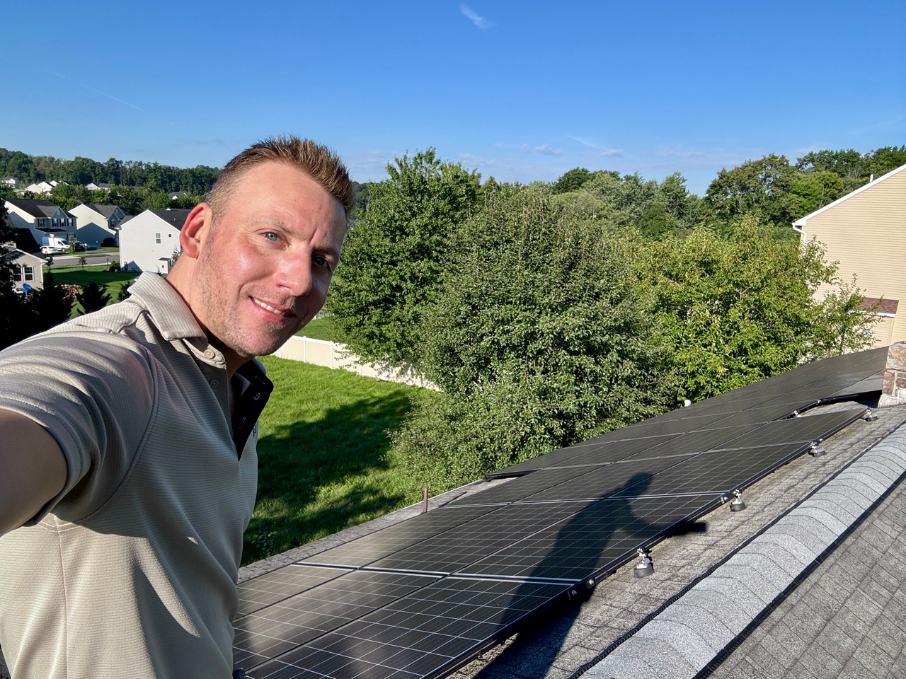 Cainen Bedsaul of TMK Inspections on a roof in Pottstown, Pennsylvania, with rooftop solar panels visible.