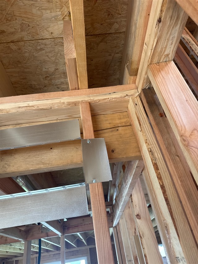 Cracked wood member visible in unfinished wall framing during a pre-drywall inspection.