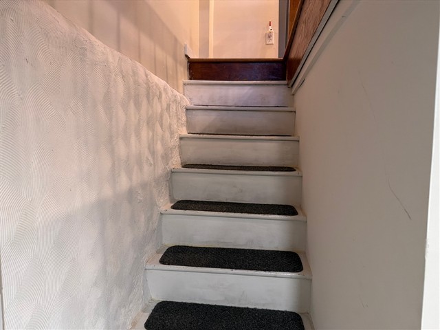 Enclosed staircase with no visible handrail along either wall.